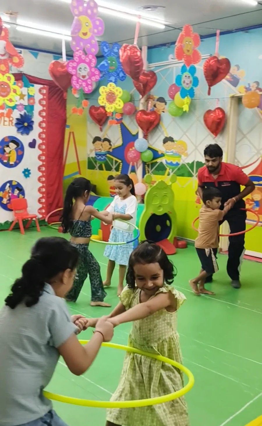 Children playing with hoops alongside an adult